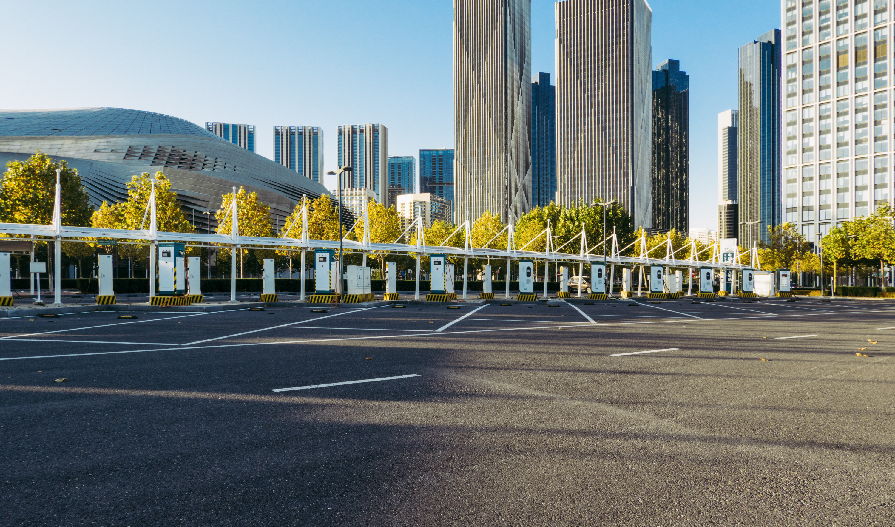 Empty EV charging station with canopy in a modern urban cityscape