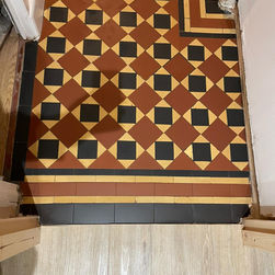 Cleaned geometric mosaic entrance tiles.