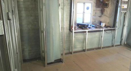 Metal stud wall partitioning around basement window