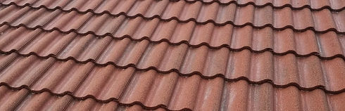 Red clay roof tiles arranged in a neat pattern, displaying a wavy texture
