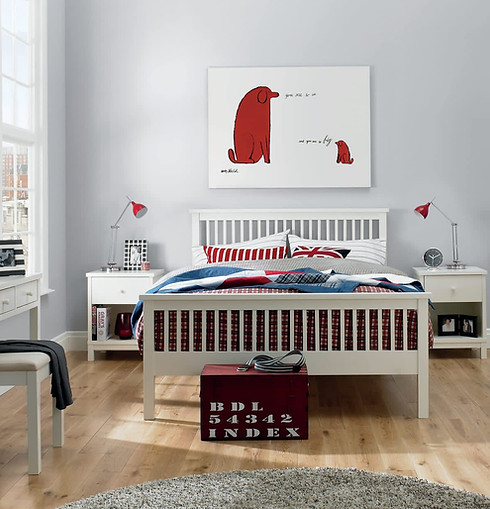 Wooden slatted bed frame with colourful bedding in a minimalist bedroom setup