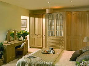Traditional wood wardrobes and a matching vanity unit in a spacious room