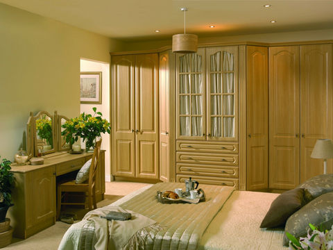 Traditional wood wardrobes and a matching vanity unit in a spacious room
