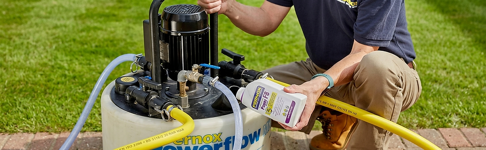 Technician adding Fernox Power F8 fluid to a Powerflow flushing machine outdoors