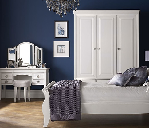 Elegant white wooden wardrobe and matching dressing table in a bright bedroom