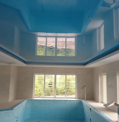Indoor swimming pool featuring blue walls, creating a serene and inviting atmosphere for relaxation and exercise