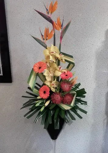 Elegant tropical arrangement with birds of paradise in a tall thin vase