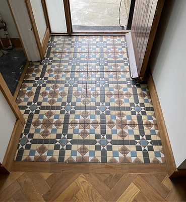 A hallway featuring a tiled floor and a closed door at the end, creating a sense of depth and perspective