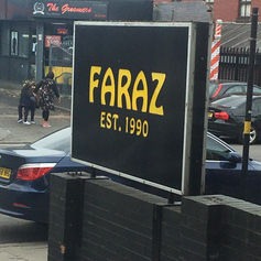 Black square projecting sign with yellow glowing text reading "FARAZ CATERING".