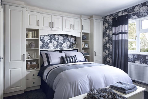 White bridge unit over a bed with black and white floral wallpaper