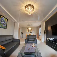 A cozy living room featuring two couches and a television against a neutral wall