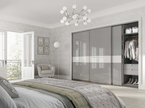 High-gloss grey sliding wardrobes in a spacious contemporary bedroom