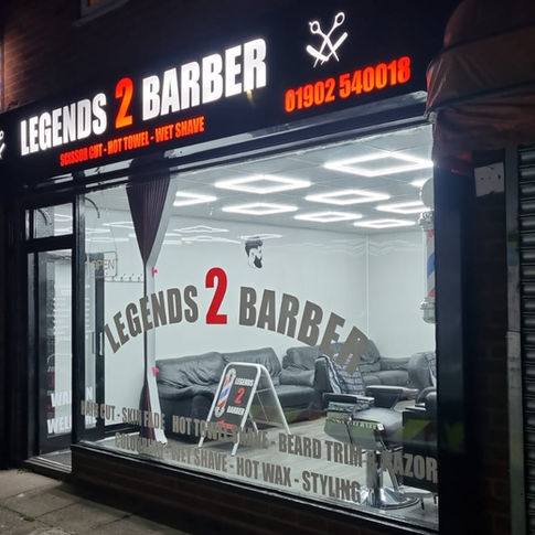 Brightly lit modern storefront at night featuring glowing white 3D block lettering above glass.