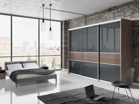 Dark wood and black sliding wardrobes in a modern minimalist bedroom