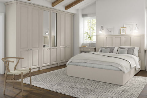 Minimalist white bedroom with floor-to-ceiling wardrobes and a large rug