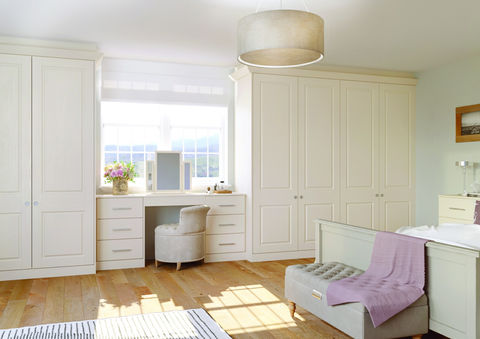 White fitted bedroom furniture featuring a dressing table under the window