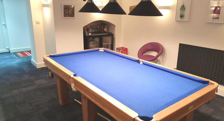 Finished games room with blue pool table and lights