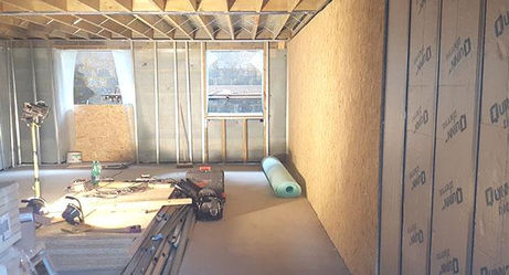 Construction site interior with exposed wooden beams and metal studs