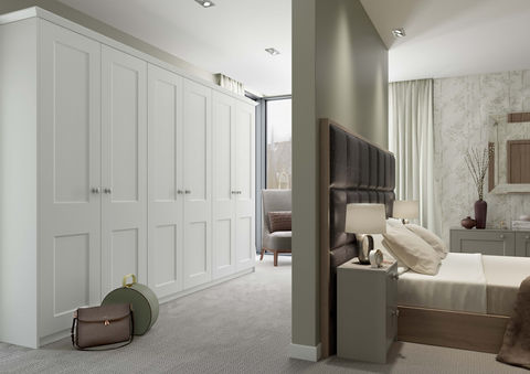 Clean white shaker-style wardrobes in a bright bedroom corridor