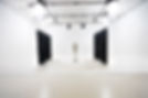 A minimalistic photography studio with bright lighting and white walls.