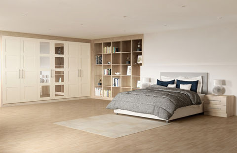 Large bedroom featuring cream wardrobes and an open bookshelf