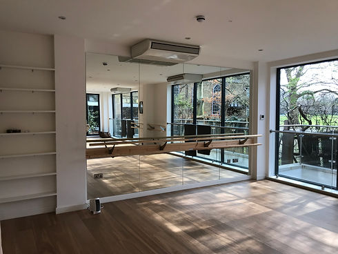 Bright, airy dance studio with wooden flooring, large mirrors
