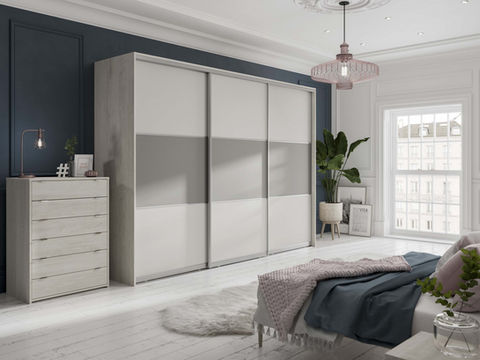 Sleek white sliding wardrobes with a matching chest of drawers