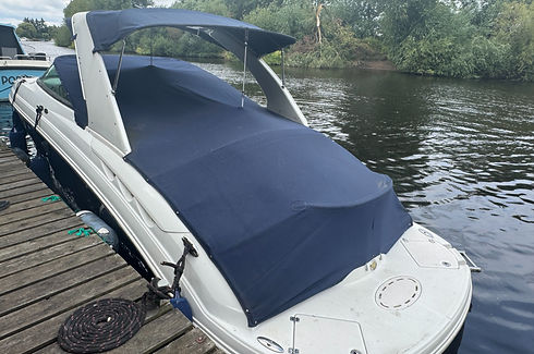 Speedboat moored at a timber dock protected by a professionally repaired dark blue canopy cover