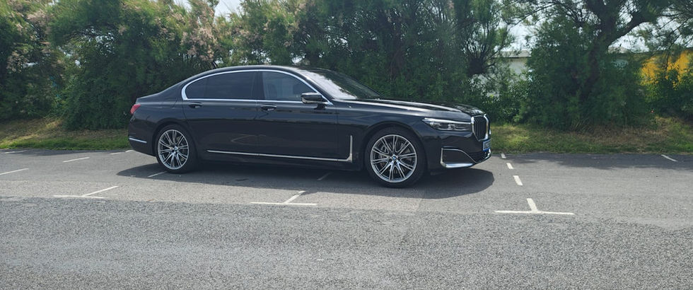 Side profile view of a black BMW sedan parked in an empty lot
