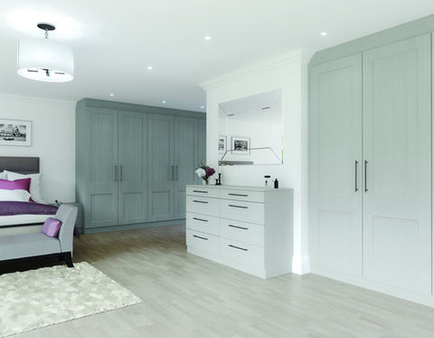 Minimalist bedroom with light blue wardrobes and a white chest of drawers