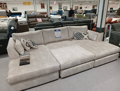 A spacious sectional couch displayed in a furniture store, showcasing its modern design and comfortable seating arrangement