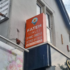 Orange rectangular projecting sign mounted high on the side corner of a building.