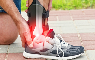 A person wearing a brace holds their ankle in pain, depicted with a glowing red overlay on the joint, indicating discomfort or injury