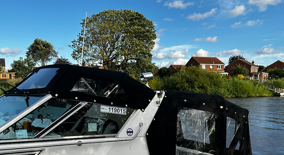 Bespoke black marine canvas canopy enclosure fitted onto a boat cruising on a river
