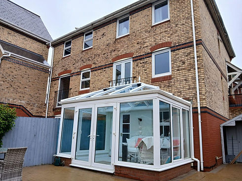 Rear view of a brick house featuring a newly installed white uPVC conservatory extension