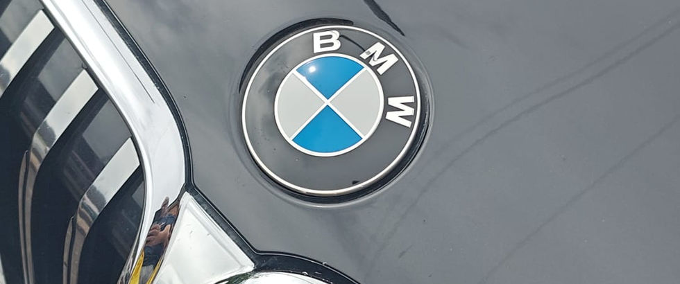 Close up of the BMW badge on the hood next to the front grille