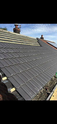 Close up of durable grey roofing tiles on a steeply pitched house