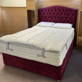 Dark red tufted headboard and divan base with a quilted mattress
