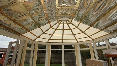 Interior view of a conservatory with partially installed roof insulation