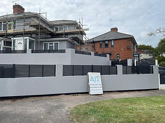 A two-story house under renovation, surrounded by scaffolding