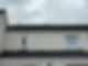 Rooftop view of a beige building with two closed windows, overcast sky