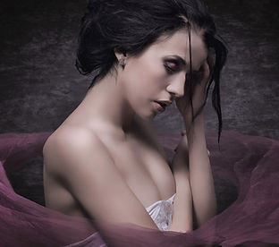 Image of a Woman in Thought with a Moody Background Description: "Portrait of a contemplative woman with a serene yet somber expression reflects introspection and emotional struggles. This image underscores the practice's commitment to supporting individuals dealing with grief, stress, and self-esteem issues.