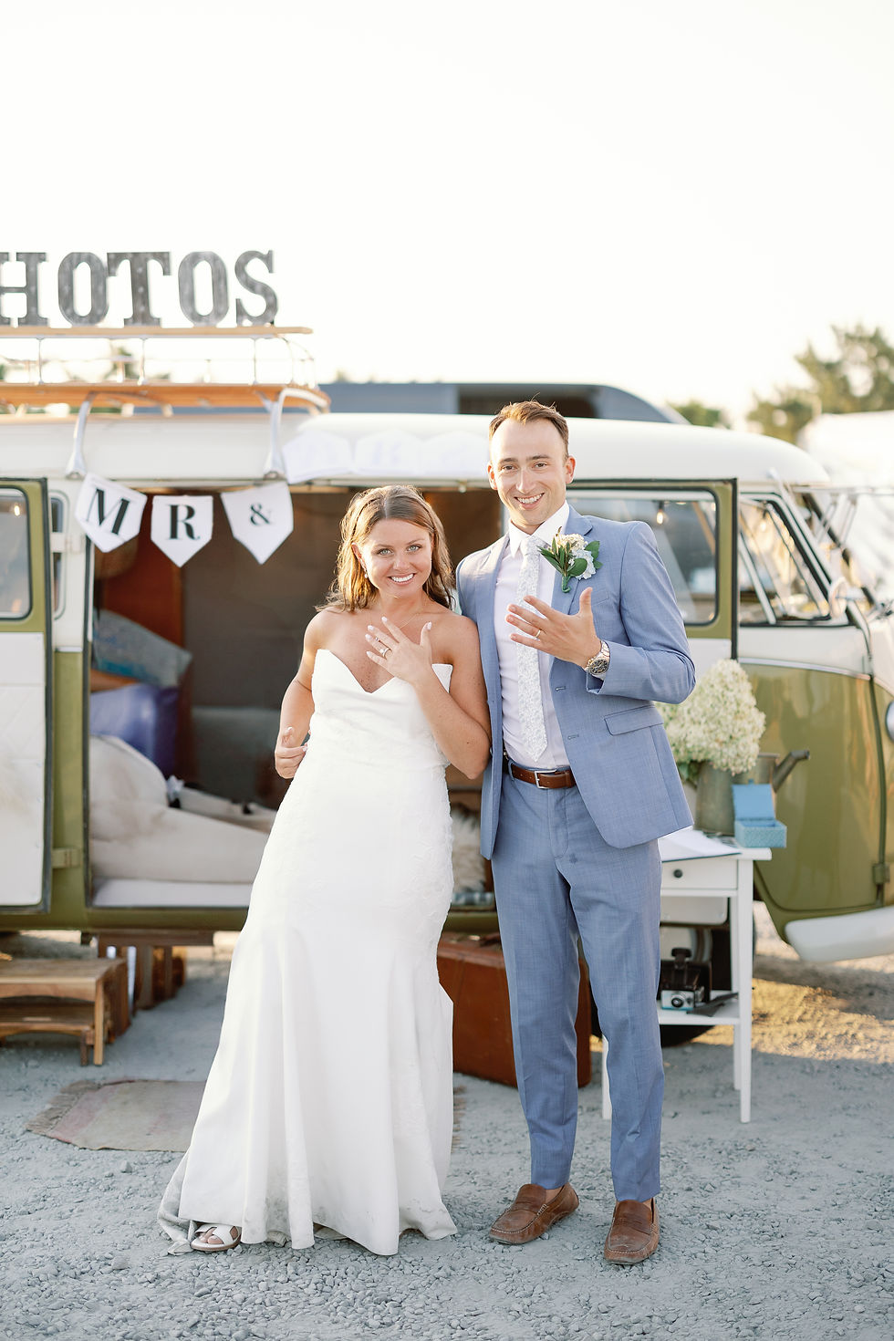 A woman and a man with the photobus in wedding attire showing their rings!