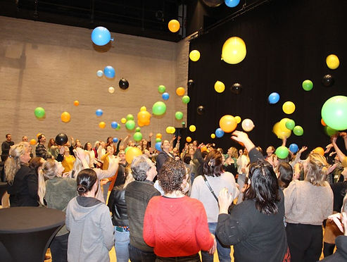deelnemers gooien ballonnen de lucht in tijdens een activerende sessie