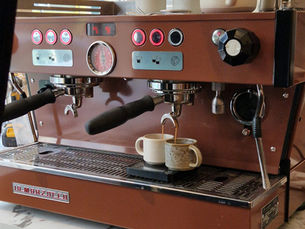 Machine à espresso La Marzocco personnalisée aux couleurs d'un coffee shop, installée sur un comptoir professionnel