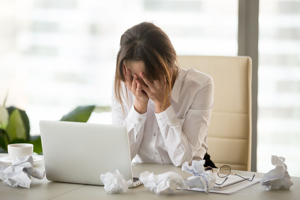 Woman stress in her desk with crumbled paper