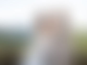 Mariés assis sur un muret en pierre face aux collines lors d'une séance photo de couple