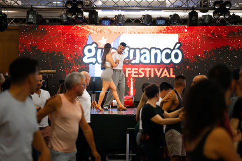 Couple dansant sur scène, Guayancó Festival, danseurs et public, ambiance festive.
