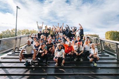 Groupe de personnes souriantes posant sur un pont, ciel bleu en arrière-plan