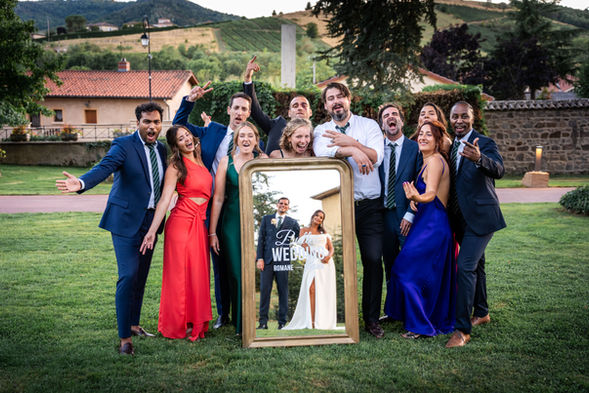 Groupe de personnes souriant, miroir avec mariés, texte « WEB » photographe vidéaste mariage